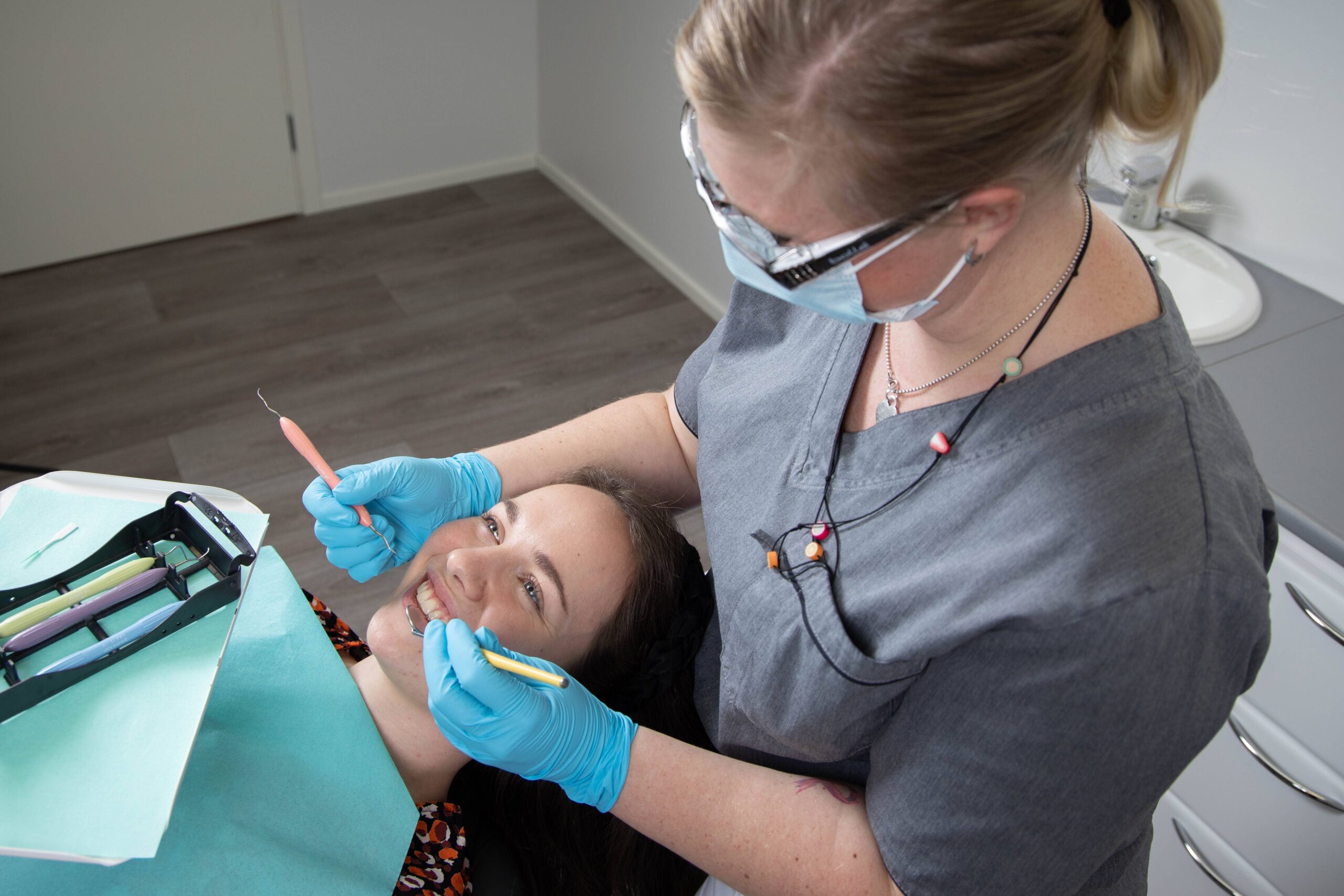 Hammaslääkäri ja potilas jolta poistetaan hammaskiveä yksityisellä hammaslääkärillä.